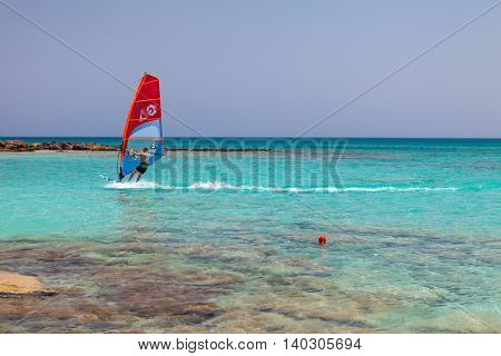 Elafonisi, Island Crete, Greece, - June 26, 2016: The windsurfer is moving in the Libyan Sea ( part of the Mediterranean Sea) on the beautiful beach of Elafonisi with pink sand.