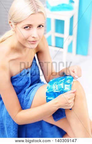 A bruised knee. The woman puts a cold compress gel knee