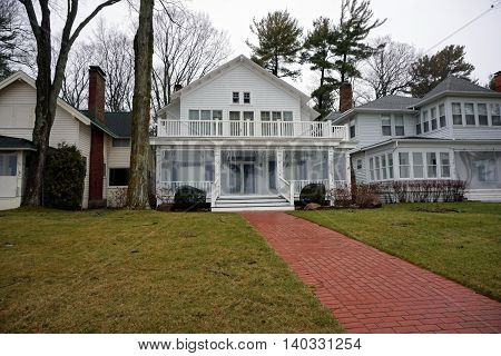 WEQUETONSING, MICHIGAN / UNITED STATES - DECEMBER 22, 2015: A brick walkway leads to a white home on Beach Drive in Wequetonsing, Michigan.