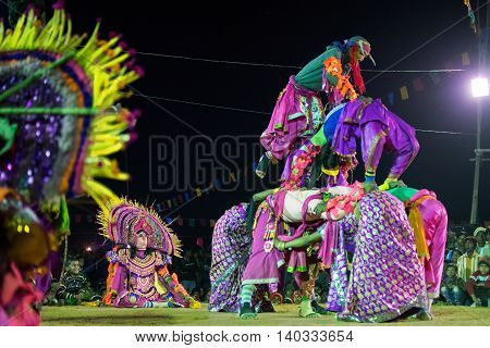 BAMNIA PURULIA WEST BENGAL INDIA - DECEMBER 23RD 2015 : Masked Dancers performing at Chhau Dance festival at night. Shot under colored light. It is a popular local Indian tribal martial dance based on Hindu myth.