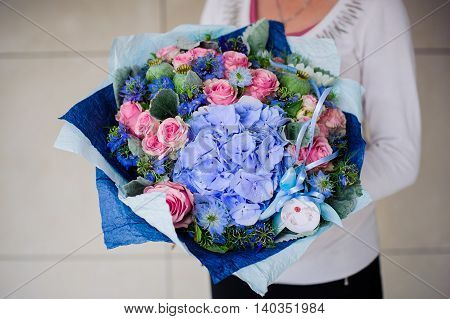 Big bouquet of white and blue flower in hands
