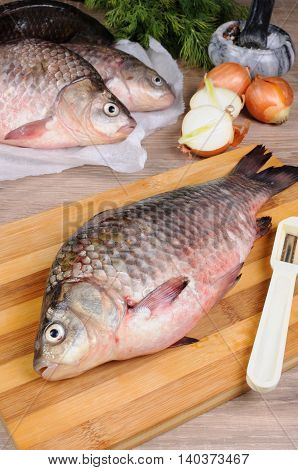 Fresh crucian carp lying on a cutting board for cutting cooked