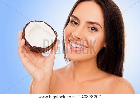Portrait Of Young Woman With Beaming Smile Holding Half Of Coconut In Hand