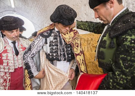 Andujar SPAIN - September 7 2014: Spainish bullfighter Miguel Abellan putting itself the walk cape in the alley before going out to bullfight typical and very ancient tradition in Andujar Spain