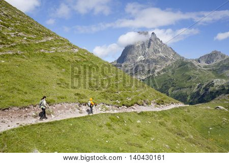 Two Girls Hiking In The Ayous Lakes Pyrenees, France, With The Midi Peak Behind
