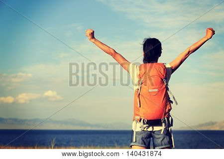young woman hiker open arms to beautiful landscape