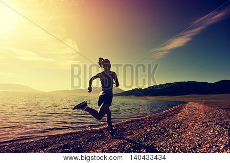 healthy young fitness woman runner running on sunrise seaside trail