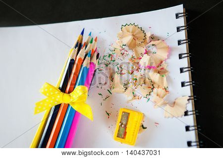 set of colored pencils bound bow with sharpener and shavings