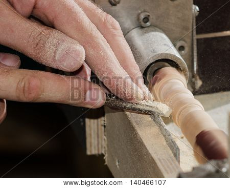 Carpenter working on the machine grind out piece of furniture