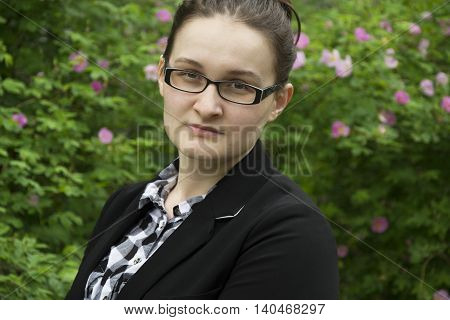 Beautiful office woman in glasses portrait. Office woman on flowers background