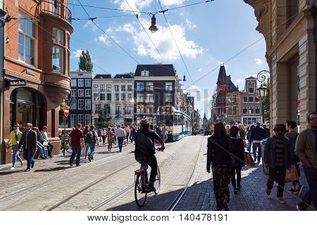 Amsterdam Netherlands - July 03 2016: Some people are traveling along the Leidsestraat street at summer time