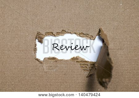 The word review appearing behind torn paper