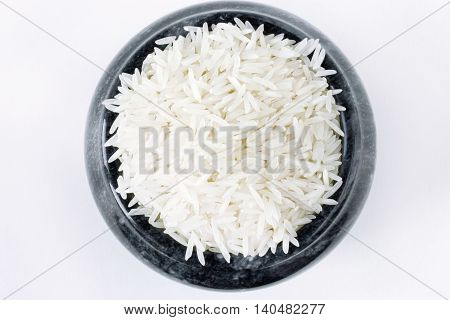 Polished long rice basmati in a stone bowl top view isolated on white background