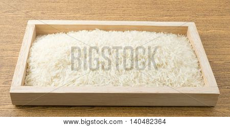 Cuisine and Food Uncooked White Long Rice Basmati Rice or Thai Jasmine Rice in Wooden Tray.