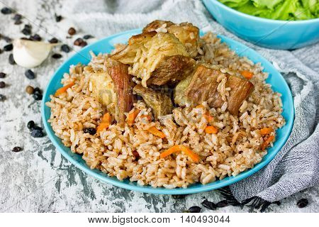 Traditional uzbek food called pilaf cooked with fried lamb meat rice carrot onion and garlic selective focus