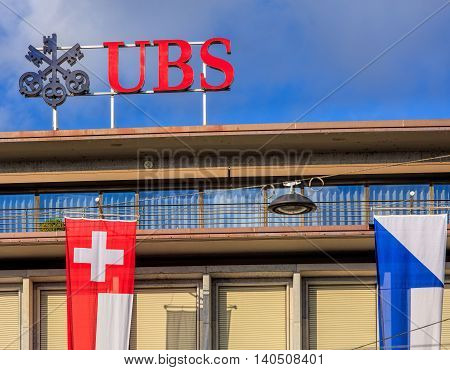 Zurich, Switzerland - 30 July, 2016: upper part of the UBS building on Paradeplatz square, decorated with flags of Switzerland and Zurich. UBS AG is a Swiss global financial services company.