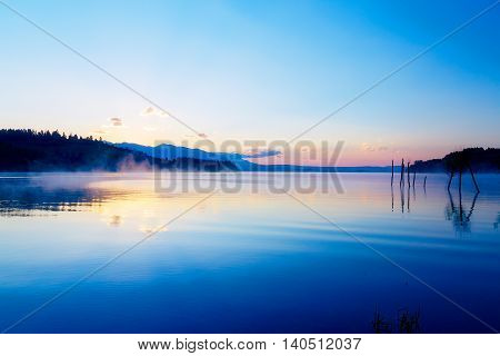 beautiful landscape with mountains and lake at dawn in golden, blue and purple tones. Slovakia Liptovska Mara, in region Liptov