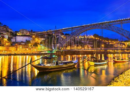 Porto, Portugal old town skyline on the Douro River with rabelo boats.