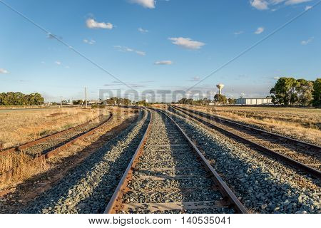 Two curved railroad tracks and one straight. One of the curved tracks has not been used for a long time judging by the rust on it.