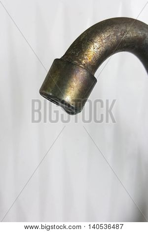 rusty faucet with water drop on white background