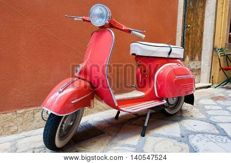 CORFU-AUGUST 22: Classic Vespa scooter parked on Kerkyra street on August 22 2014 on Corfu island. Greece. Vespa is an Italian brand of scooter manufactured by Piaggio.