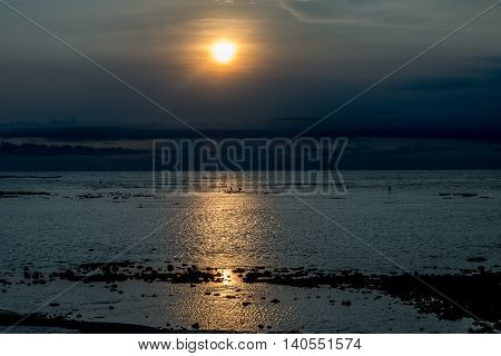 Sunset in Bali with fishermen in the distance
