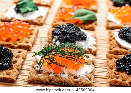 Group of snacks with red and black caviar