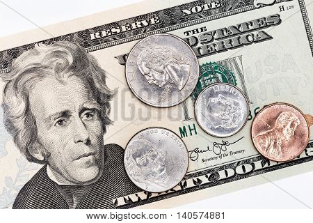 Twenty american dollars banknote, partial front face with coins of all denominations