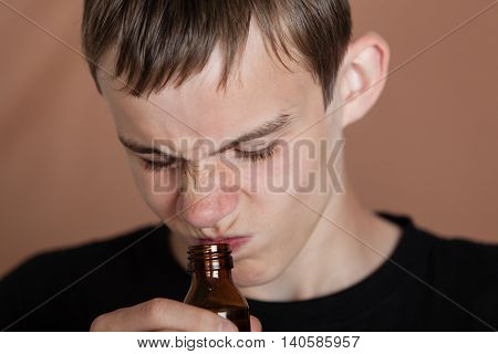 Teenage Boy Wrinkling Nose At Odor Of Medicine