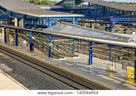 Modern railway station Camp de Tarragona (Spain): platforms tracks escalators. Horizontal.