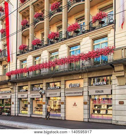 Zurich, Switzerland - 30 July, 2016: a person who looks as if being homeless is looking at the window of a store offering luxurious watches on Bahnhofstrasse street. Bahnhofstrasse is one of the world's most expensive shopping avenues.