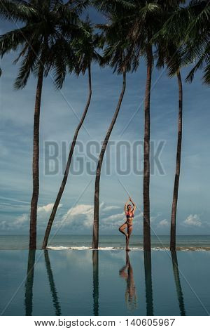 Yoga by woman on the beach near the ocean