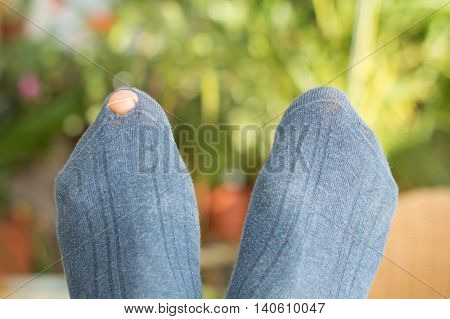 Toe looking through hole in a blue sock