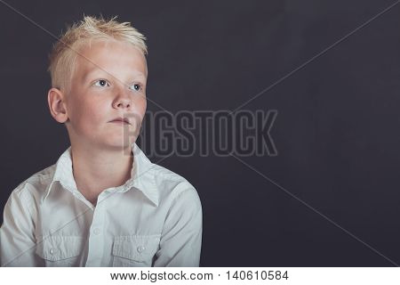Pensive Young Boy Looking Upward Over Black