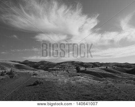 Clouds shoot across the sky in a Black and White scene at the Painted Hills of Oregon.