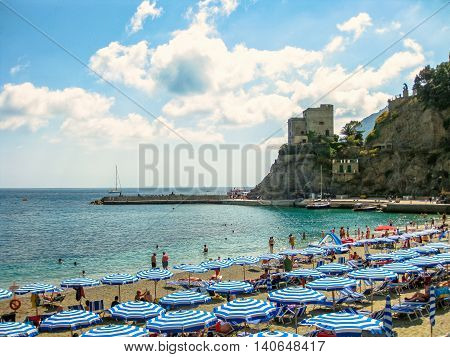 Monterosso al Mare, Ligurian Coast, Italy - June 4, 2010: beach umbrellas, deck chairs and people sunbathing in popular Monterosso Beach, the largest village of the Cinque Terre National Park.