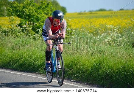GRAFHAM, CAMBRIDGESHIRE, ENGLAND - MAY 22, 2016:  Close up of Male triathlete  competitor on road cycling stage.