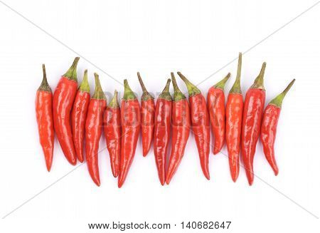 Lined up pile of red italian peppers isolated over the white background