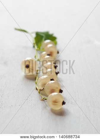 White Currant Bunch with Green Leaf on Arranged on Light Gray Wooden Table. Vertical.