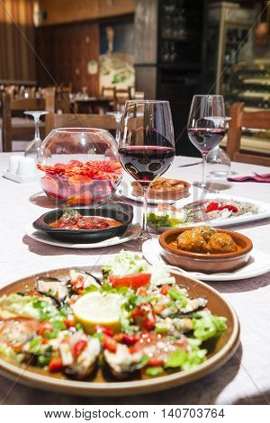 tradirional spanish cuisine paella with mussels and vegetables with starters and wine