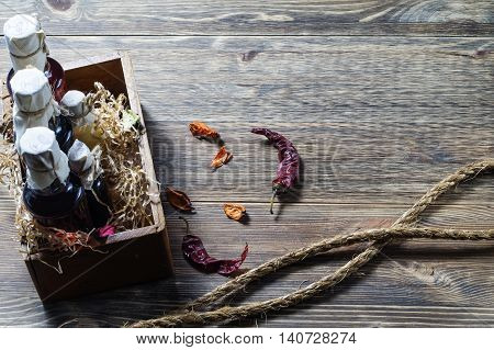 Small bottles of liquor in a wooden box on a wooden background. Small bottle with alcohol.