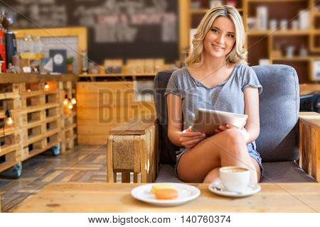 Young Hipster Girl Using Tablet Computer In Coffee Shop