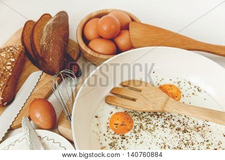 Fried Eggs in the  Pan,Breakfast Ingredients.Orange,Bread,Butter.Kitchen Accessories.Cooking Morning Food.Selective Focus