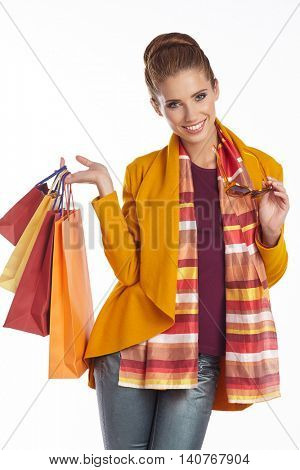 Woman wearing autumn overcoat and scarf  holding shopping bag.