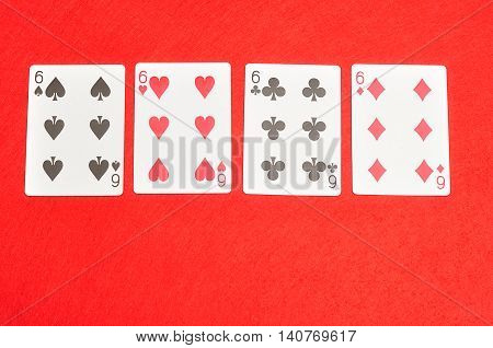 The different suit of the number 6 cards in a deck of cards displayed on a red background