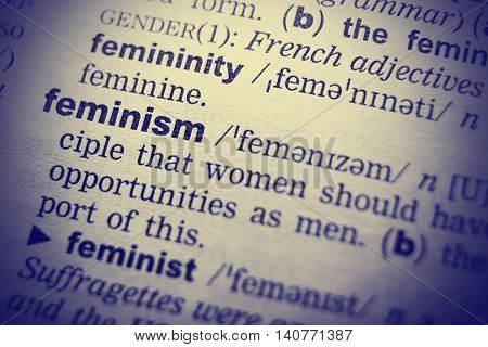 Feminism word in English dictionary. Close-up shot.
