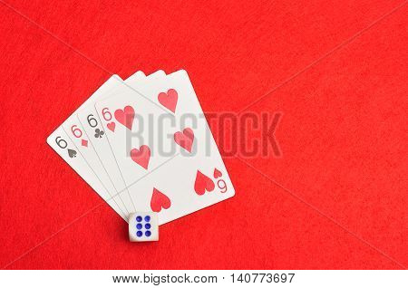 The different suit of the number 6 cards in a deck of cards displayed on a red background with a dice