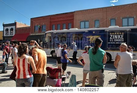 KALISPELL, MT, USA - JULY 4: US Congressman Ryan Zinke (R-MT) waves at the crowd while marching with his campaign bus at the 4th of July Parade in Kalispell, Montana, on July 4, 2016.