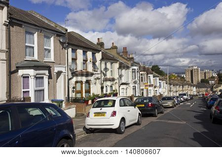 LONDON, UNITED KINGDOM - SEMPTEMBER 12 2015: Row of traditional British houses in a street in the suburbs of London with car parked on the street