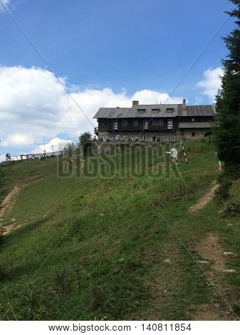 Romania, August 25, 2015, Ceahlau Massif, Moldova, People near a large cottage on the mountains